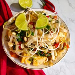 Vegan Pad Thai served in a white bowl garnished with lime wedges