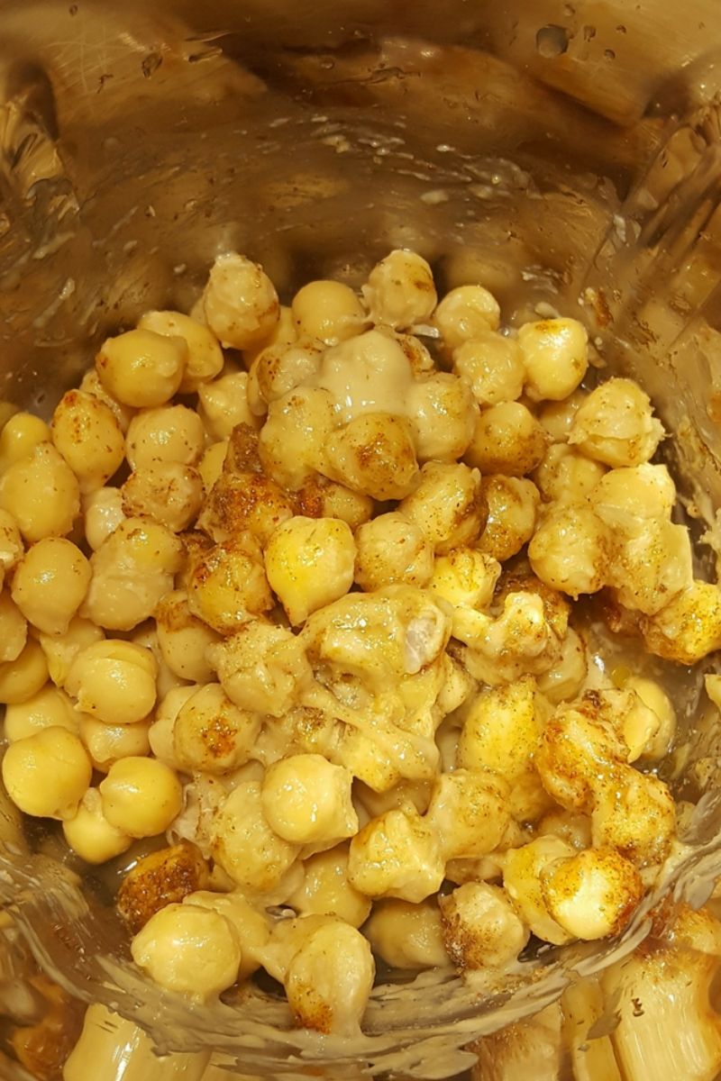 Chickpeas, tahini and other hummus ingredients inside a mixing jar