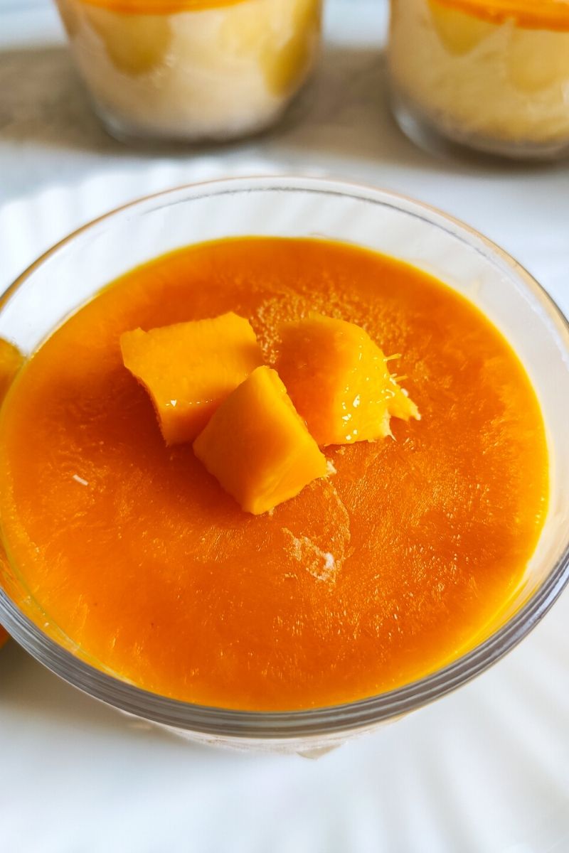 Mango Cheesecake Ice cream in a glass bowl garnished with mango cubes