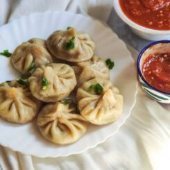 Tibetan dumplings -veg momos served on a white plate with momos chutney
