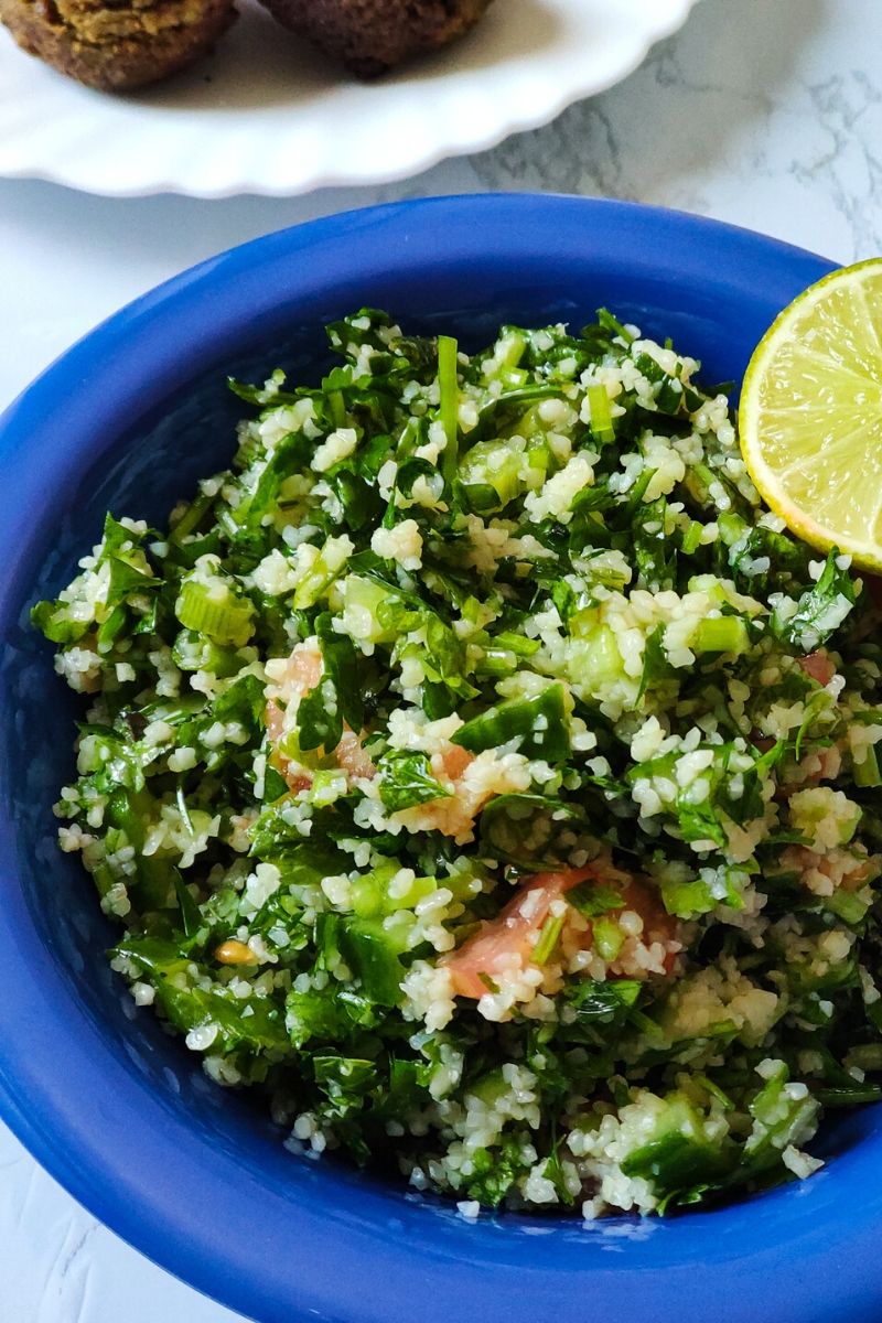 Middle Eastern Salad Tabbouleh serve in a blue bowl with a lime wedge on top