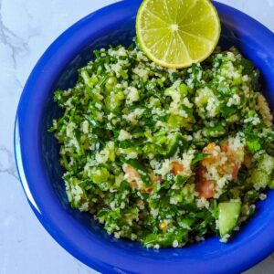 Middle Eastern Salad Tabbouleh serve in a blue bowl with a lime wedge on top