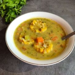 Trinidad corn soup in a bowl with cilantro in the background