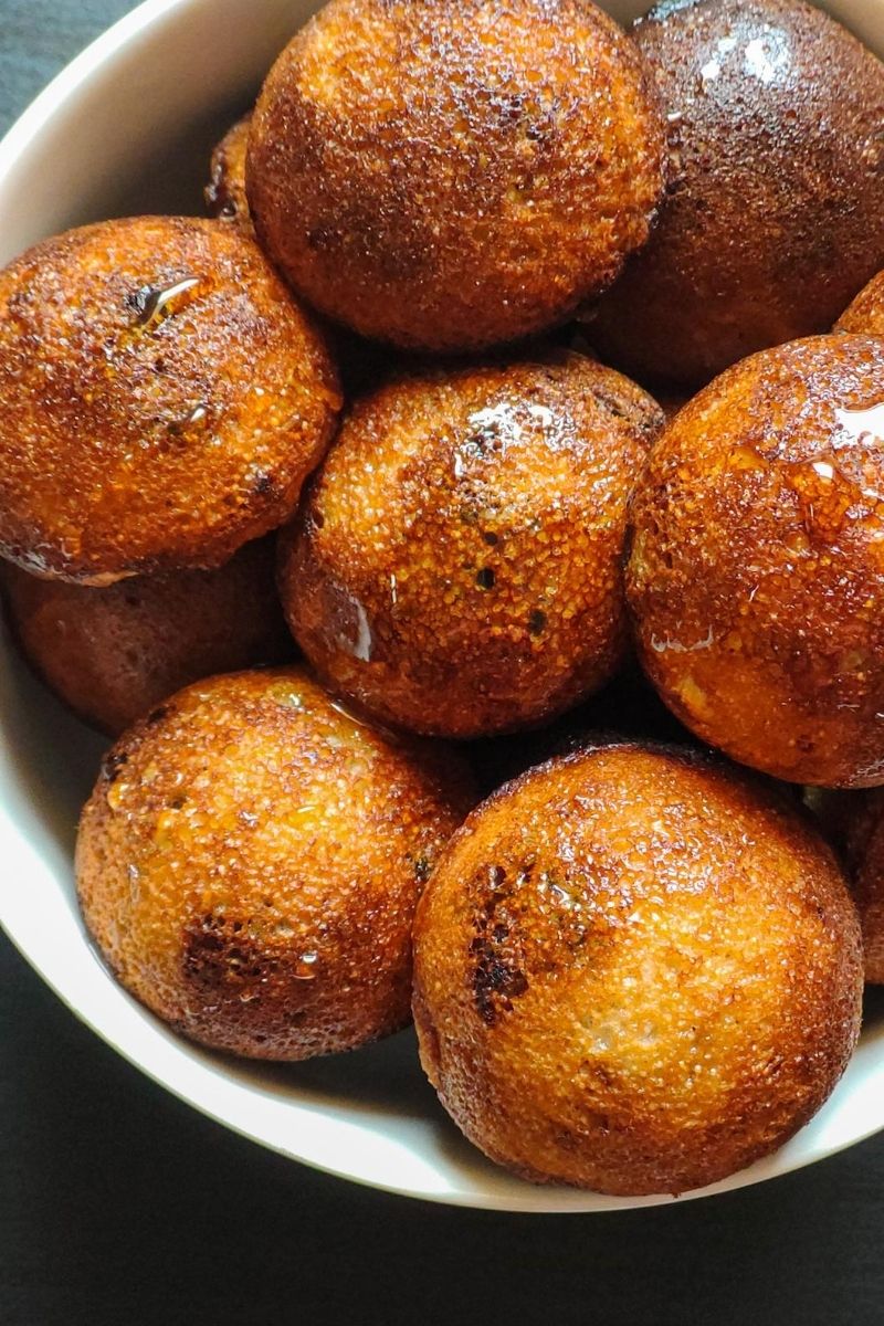 close up shot of sweet paniyarams in a white bowl