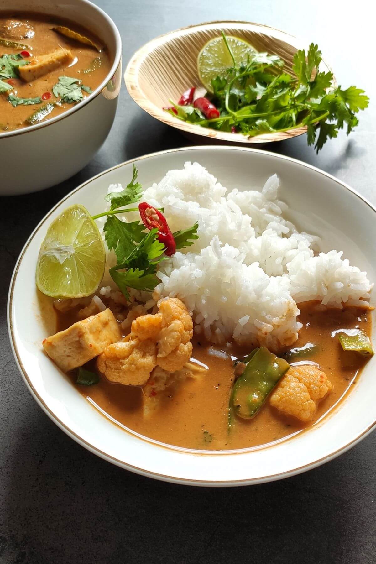 Vegetable Thai red curry with vegetables served in a white bowl with rice