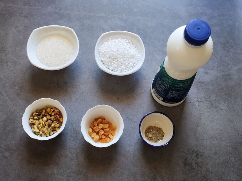 Ingredients required to make sabudana kheer on a grey surface