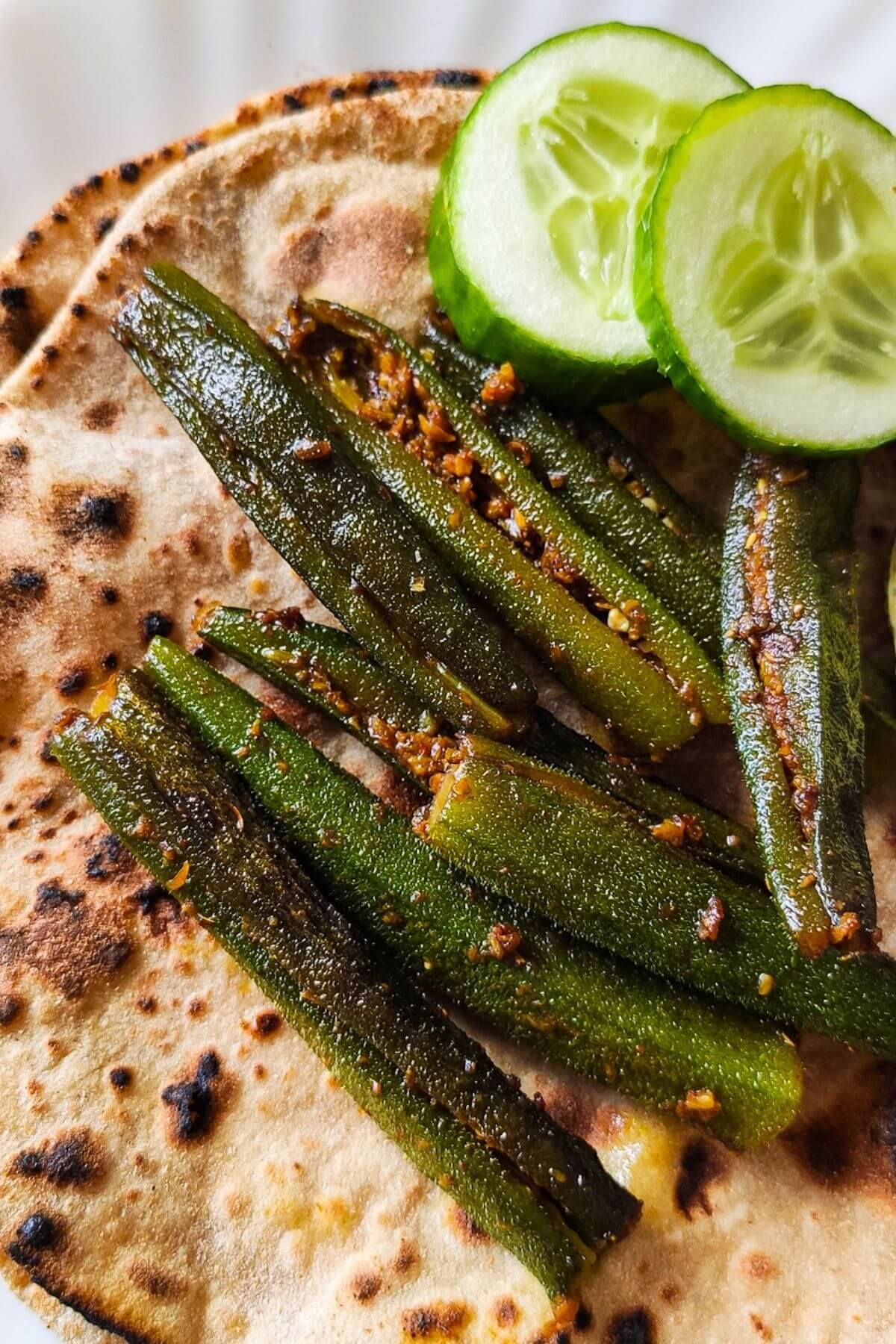 stuffed bhindi and cucumber slices served on top of roti.