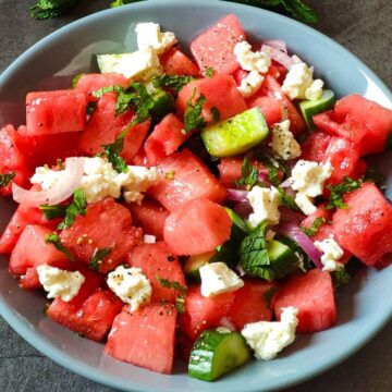 Greek style watermelon salad served in a grey bowl