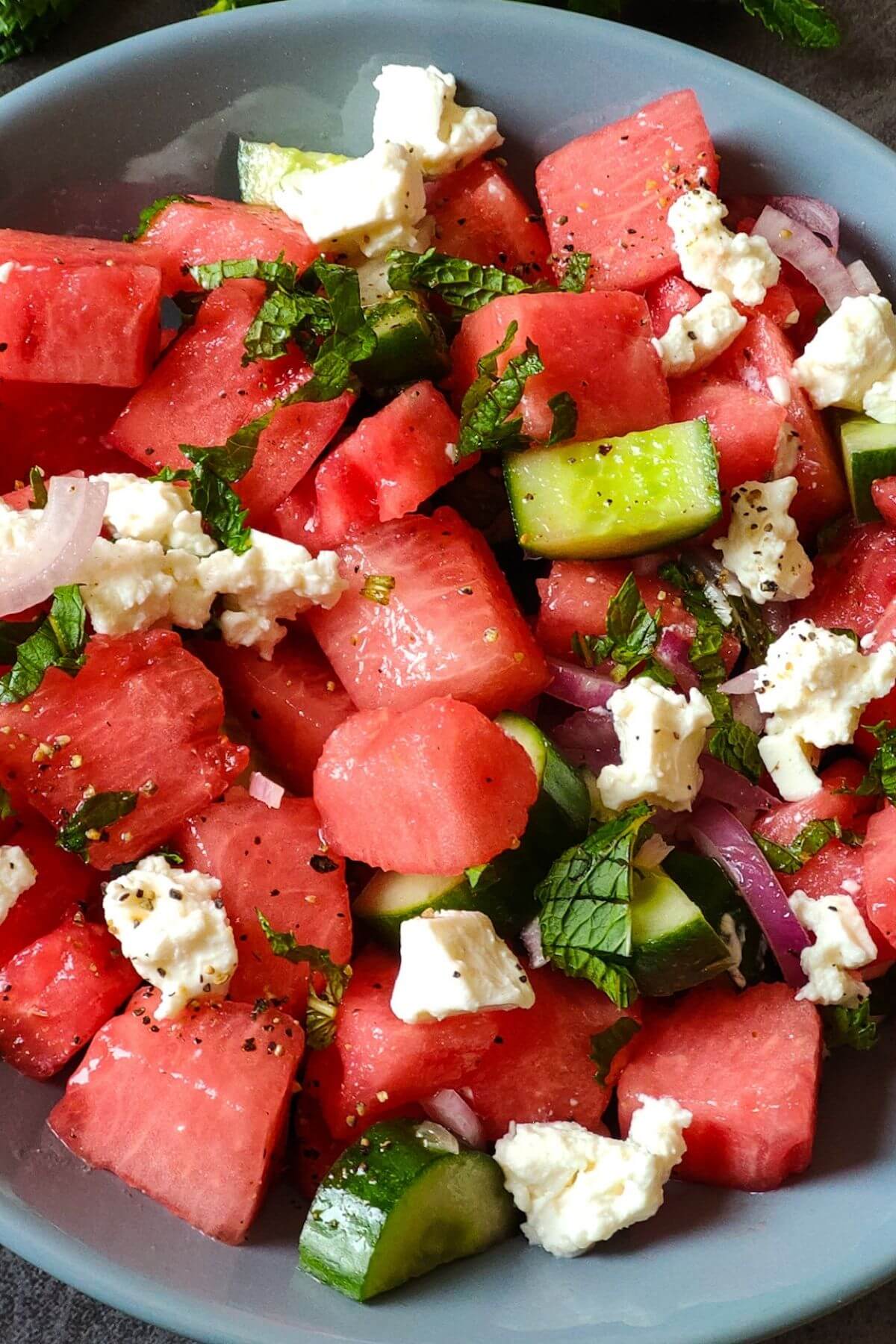 Greek watermelon salad with feta served in a grey bowl