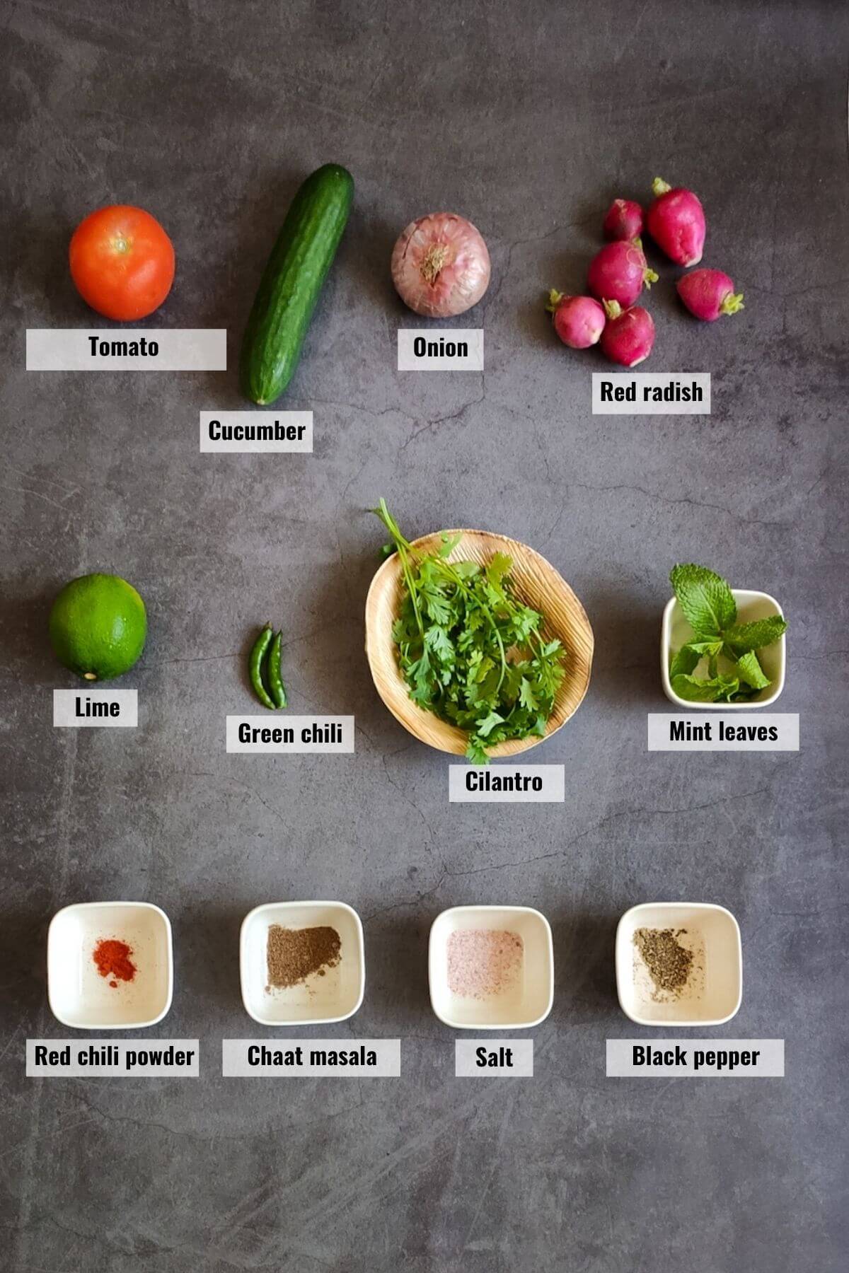 Ingredients for kachumber salad kept on a grey surface