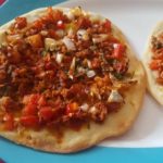 vegan lahmacun a thin crust turkish pizza served on a white plate with blur border