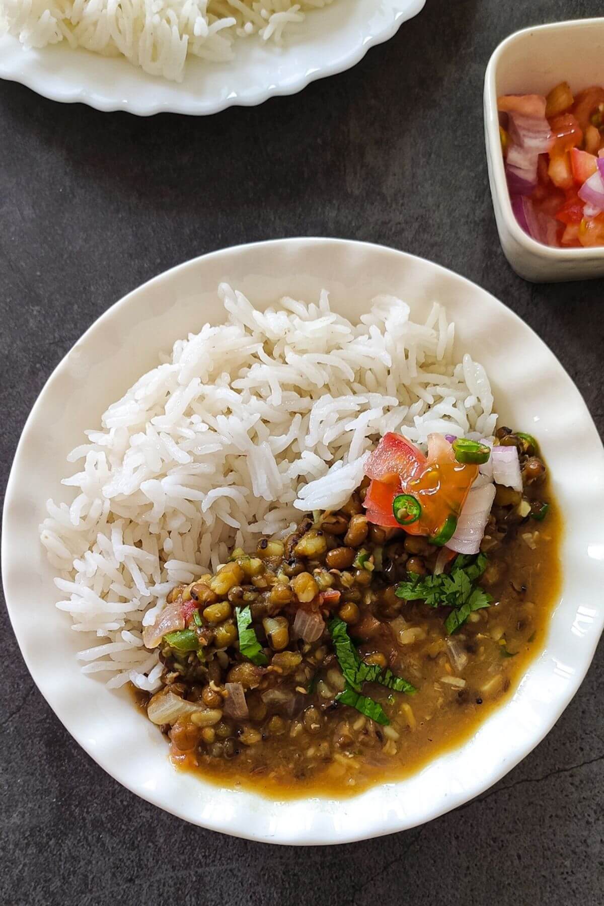 moong dal served in a white bowl with rice and salad.