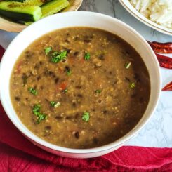 Urad Chana dal served in a white bowl with rice and salad