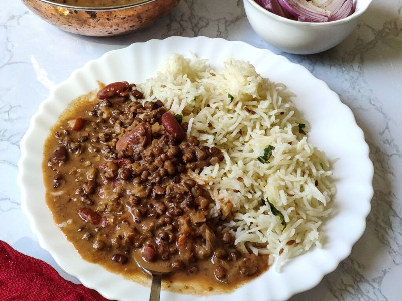 Dal makhani served with rice on a white plate