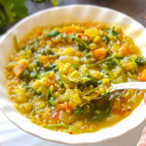 A bowl of red lentil and quinoa soup.