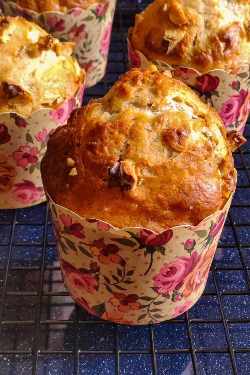 Vegan banana muffins in floral paper muffin molds kept on a cooling rack