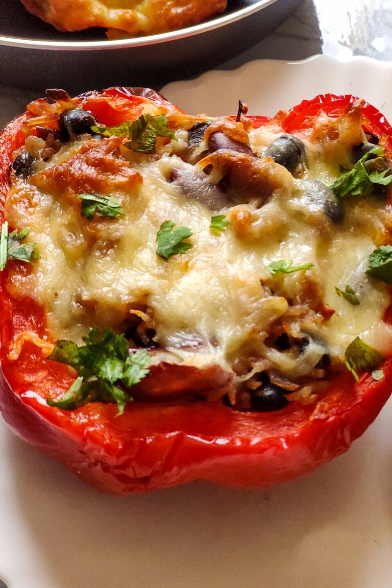 one piece of stuffed red bell pepper kept on a white plate