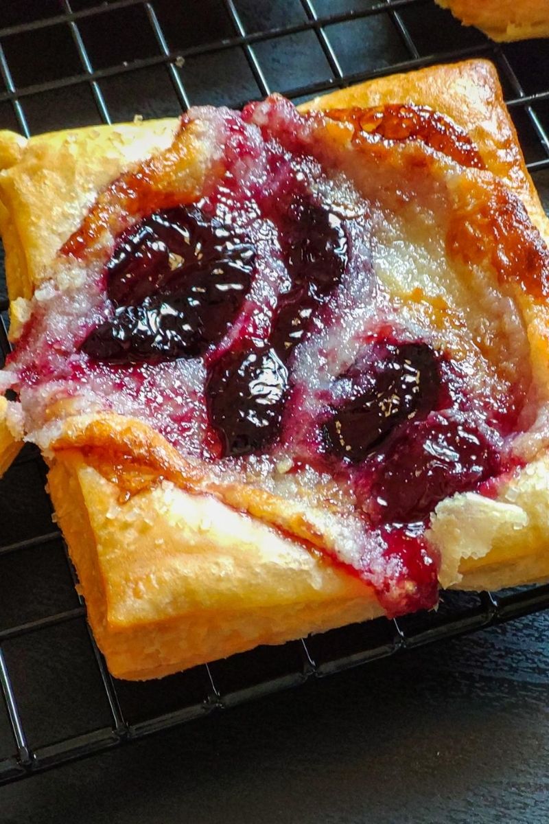 A cherry cream cheese danish on a cooling rack