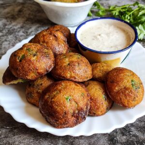 Veg paniyaram serve on a plate with a bowl of chutney