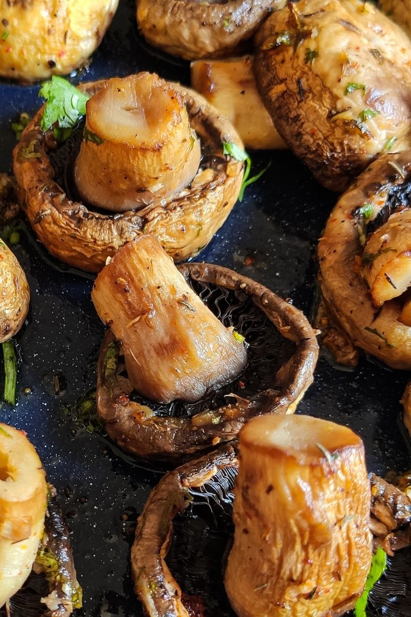 roasted mushrooms garnished with coriander leaves on a baking tray