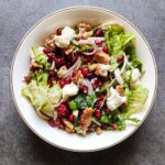 Pomegranate salad with feta in a white bowl