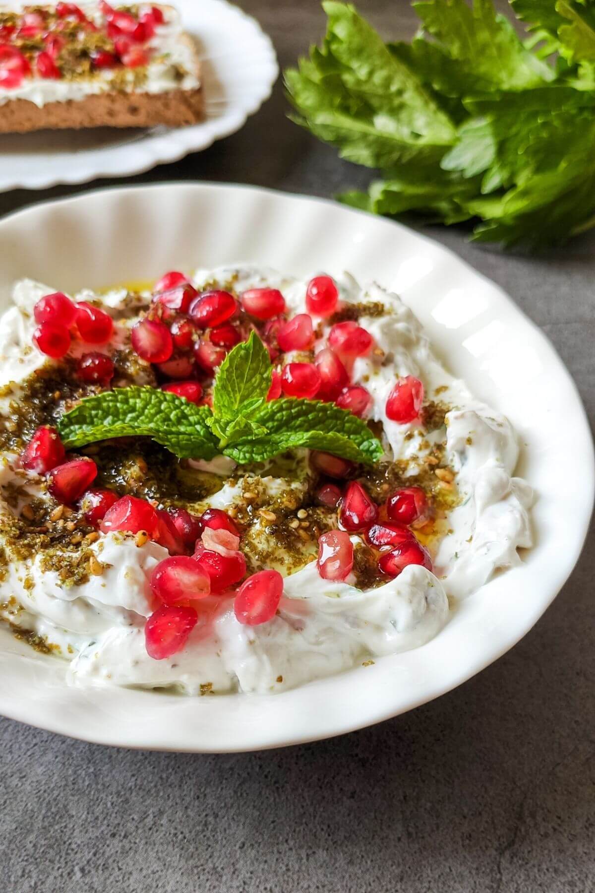 Labneh dip garnished with za'atar, pomegranate, and mint leaves