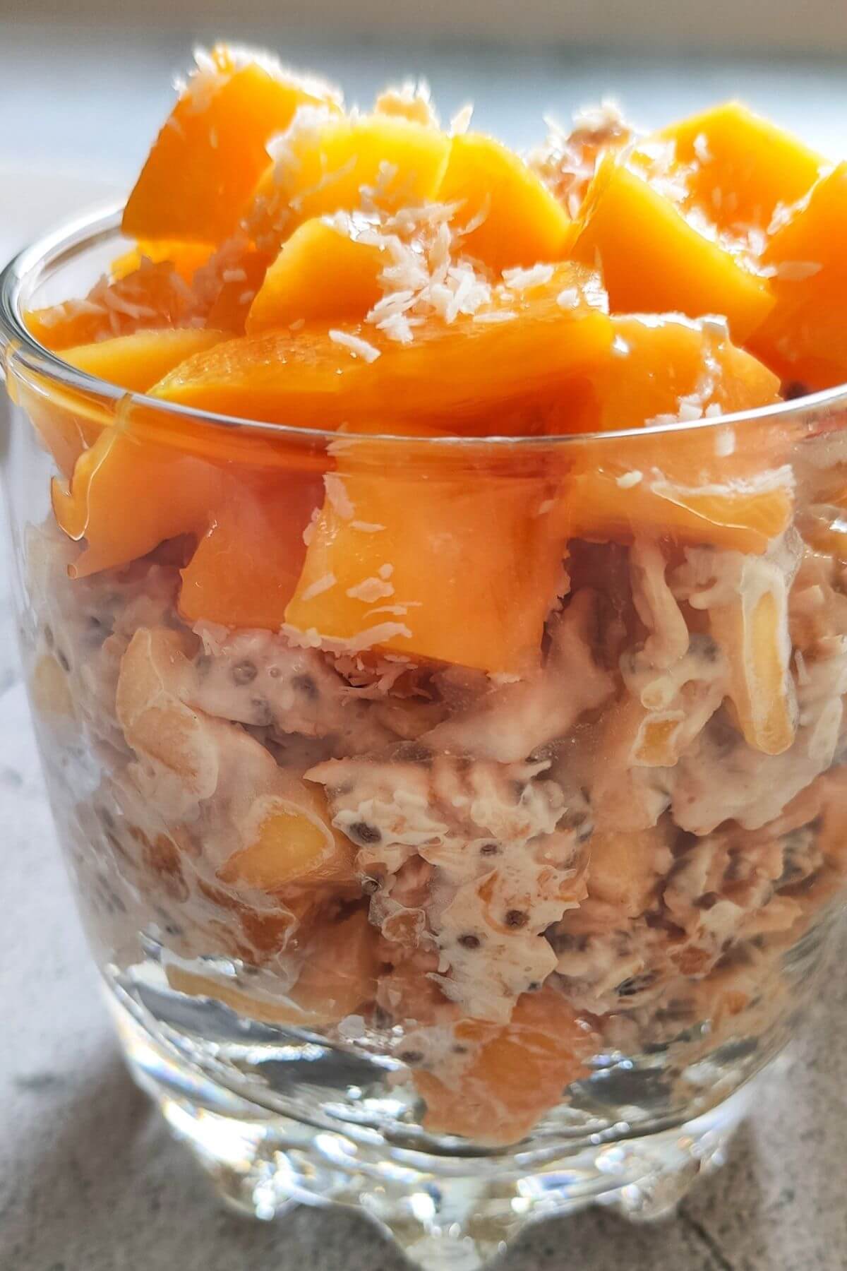Mango overnight oats in a glass bowl