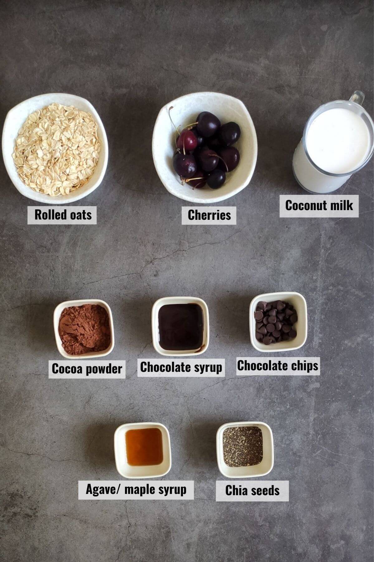 Ingredients requited to make chocolate cherry oats kept on a grey surface