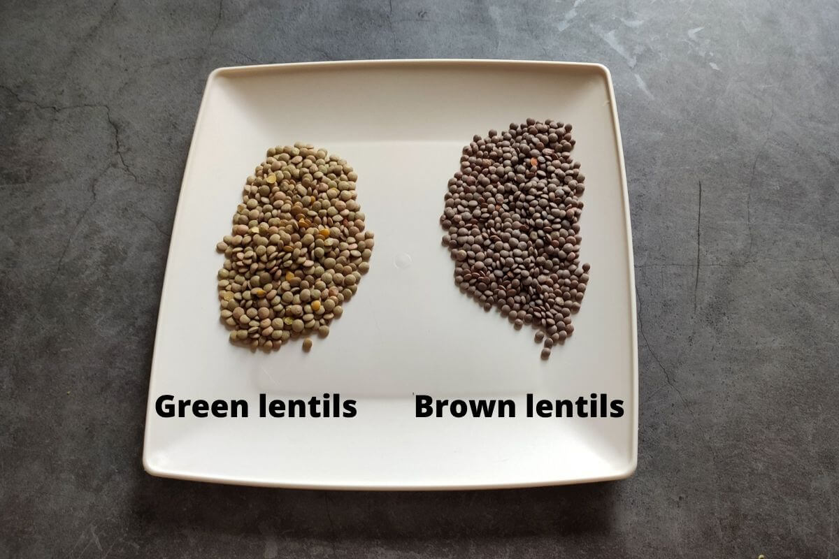 Green lentils and brown lentils kept on two opposite sides of a white square dish