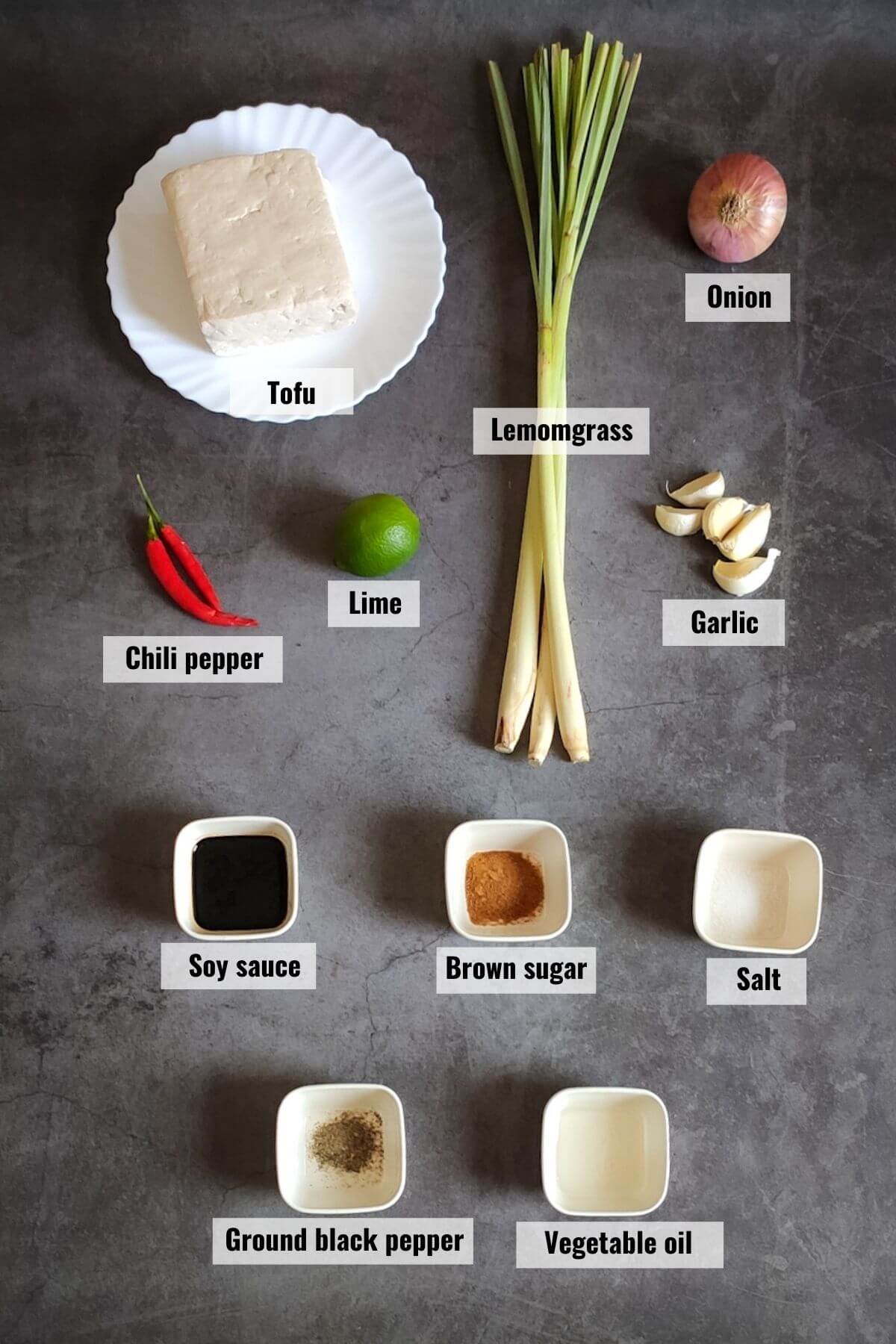 Ingredients required to make lemongrass tofu kept on a grey surface.