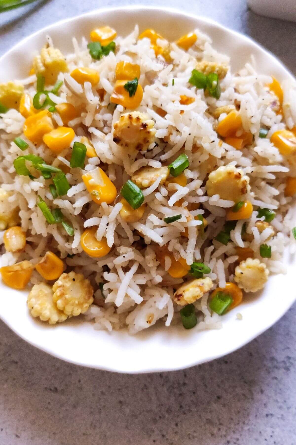 corn fried rice served in a white bowl.