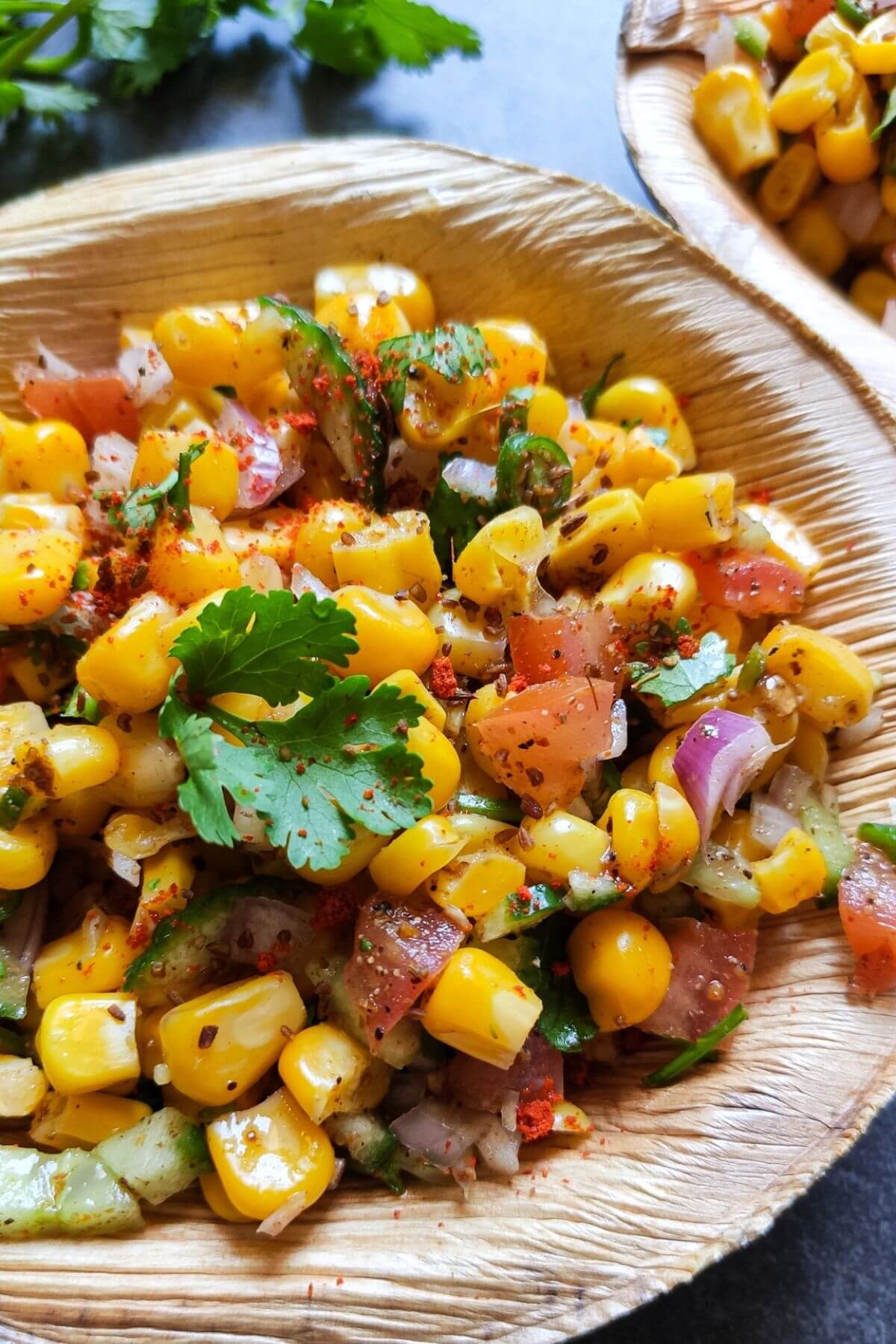 Masala corn served in a small wooden bowl.