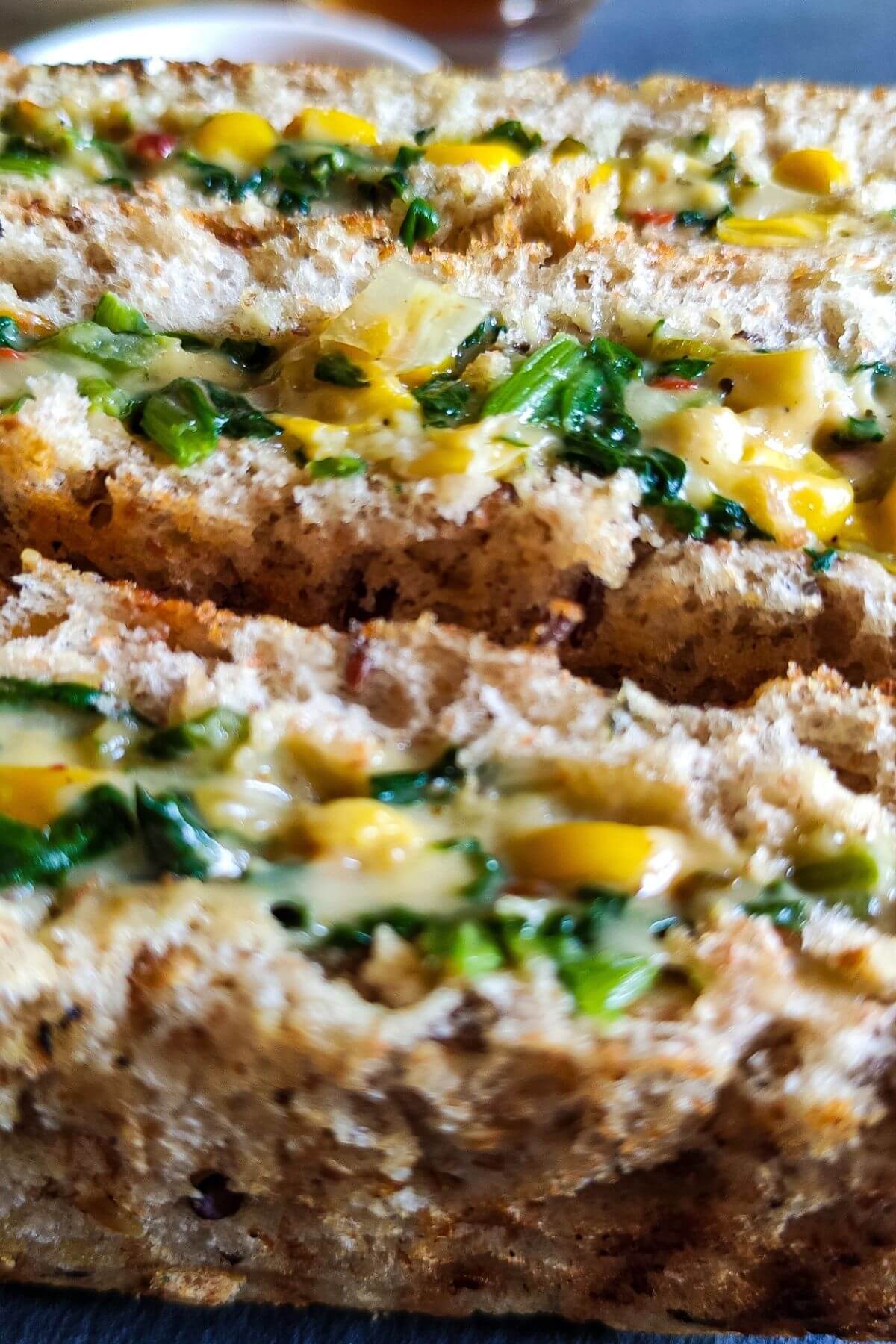 close up shot of cheese corn sandwiches with spinach.
