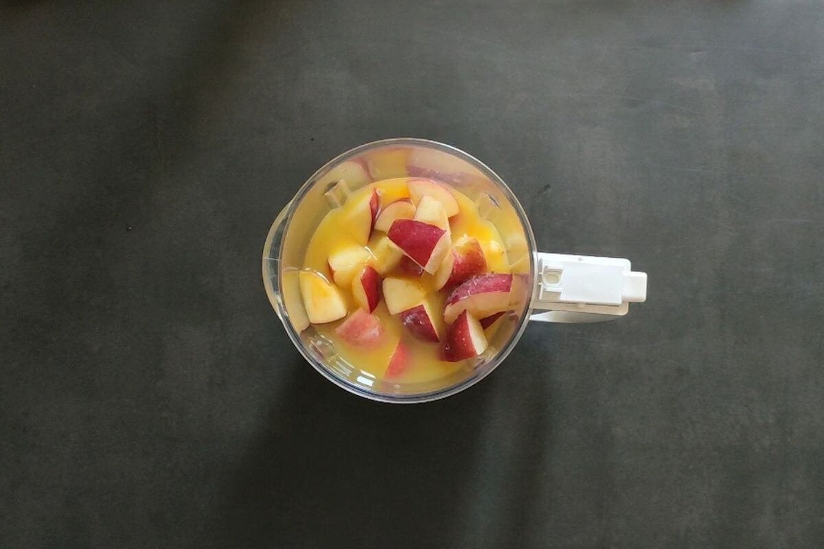 frozen apples and orange juice in a blending jar.