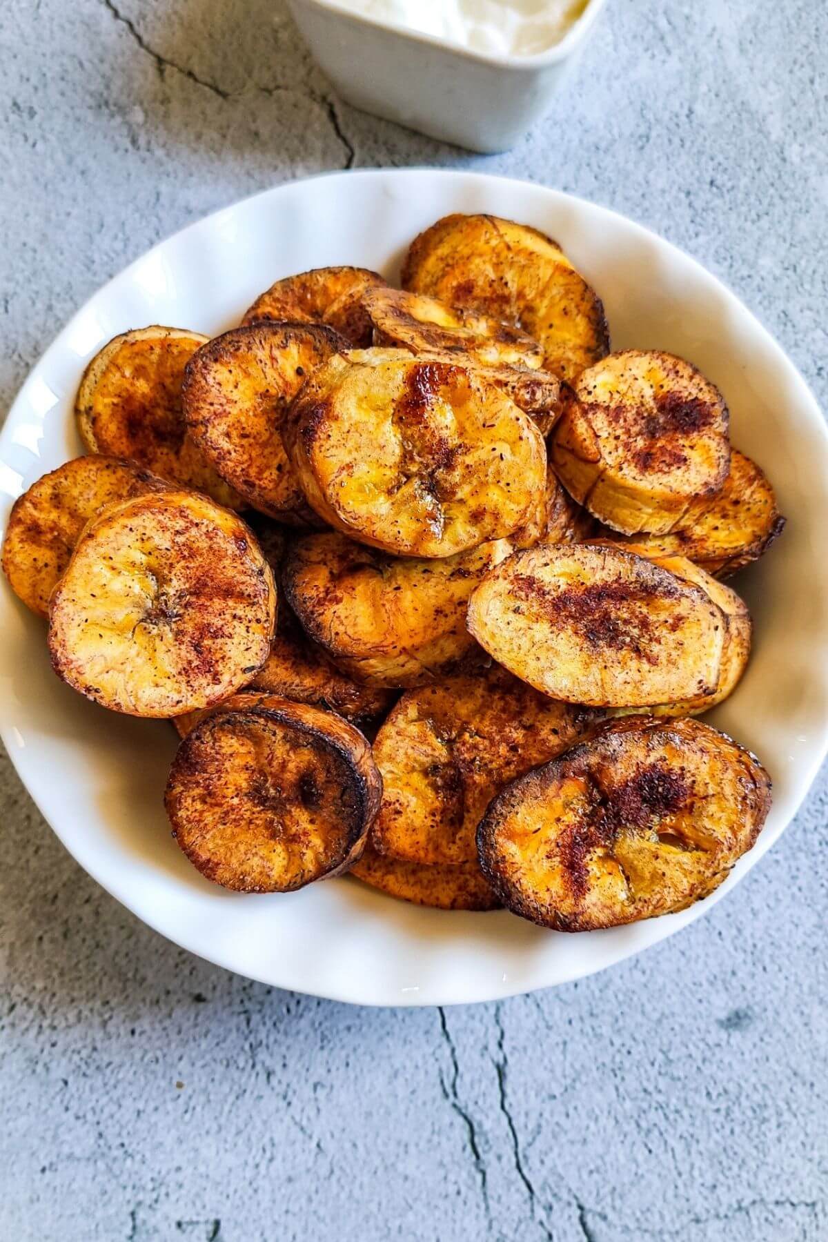 Sweet baked plantain in a white bowl.