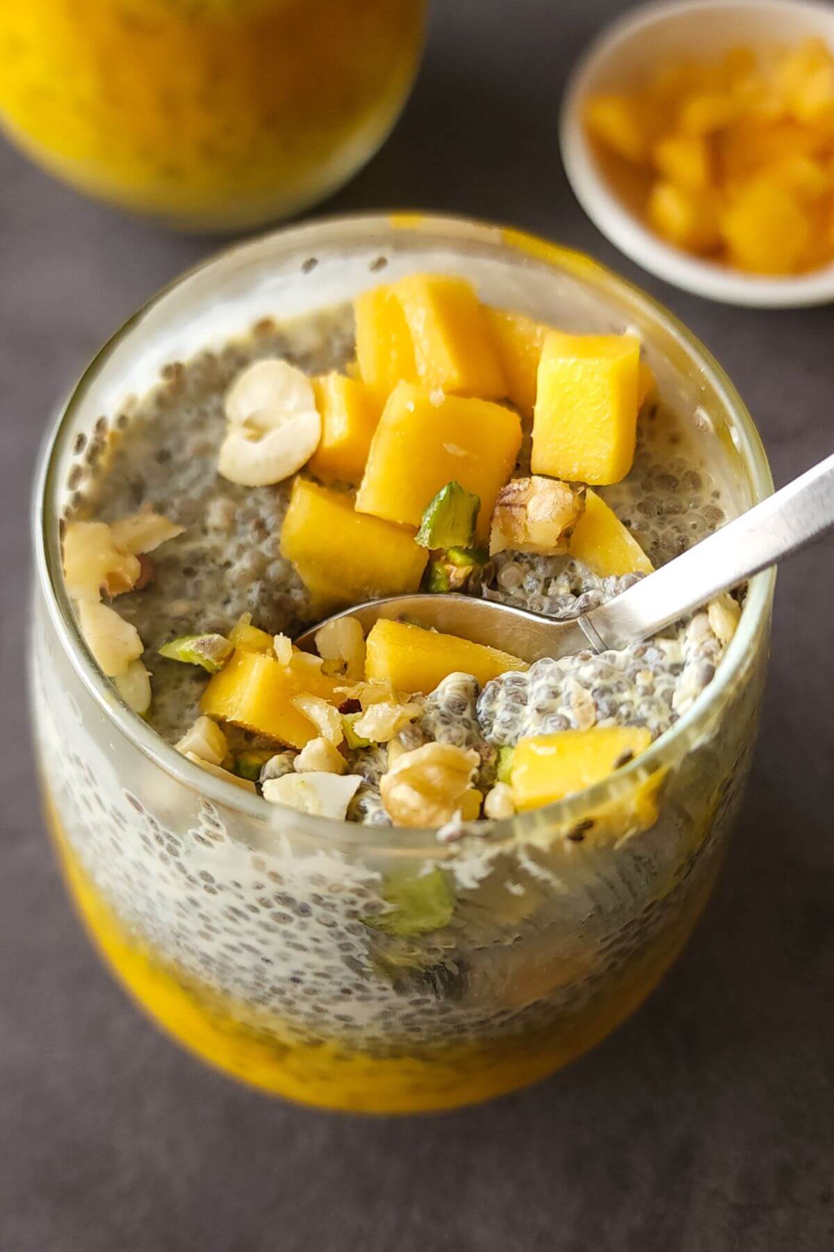 Mango chia seeds pudding in a glass with a spoon
