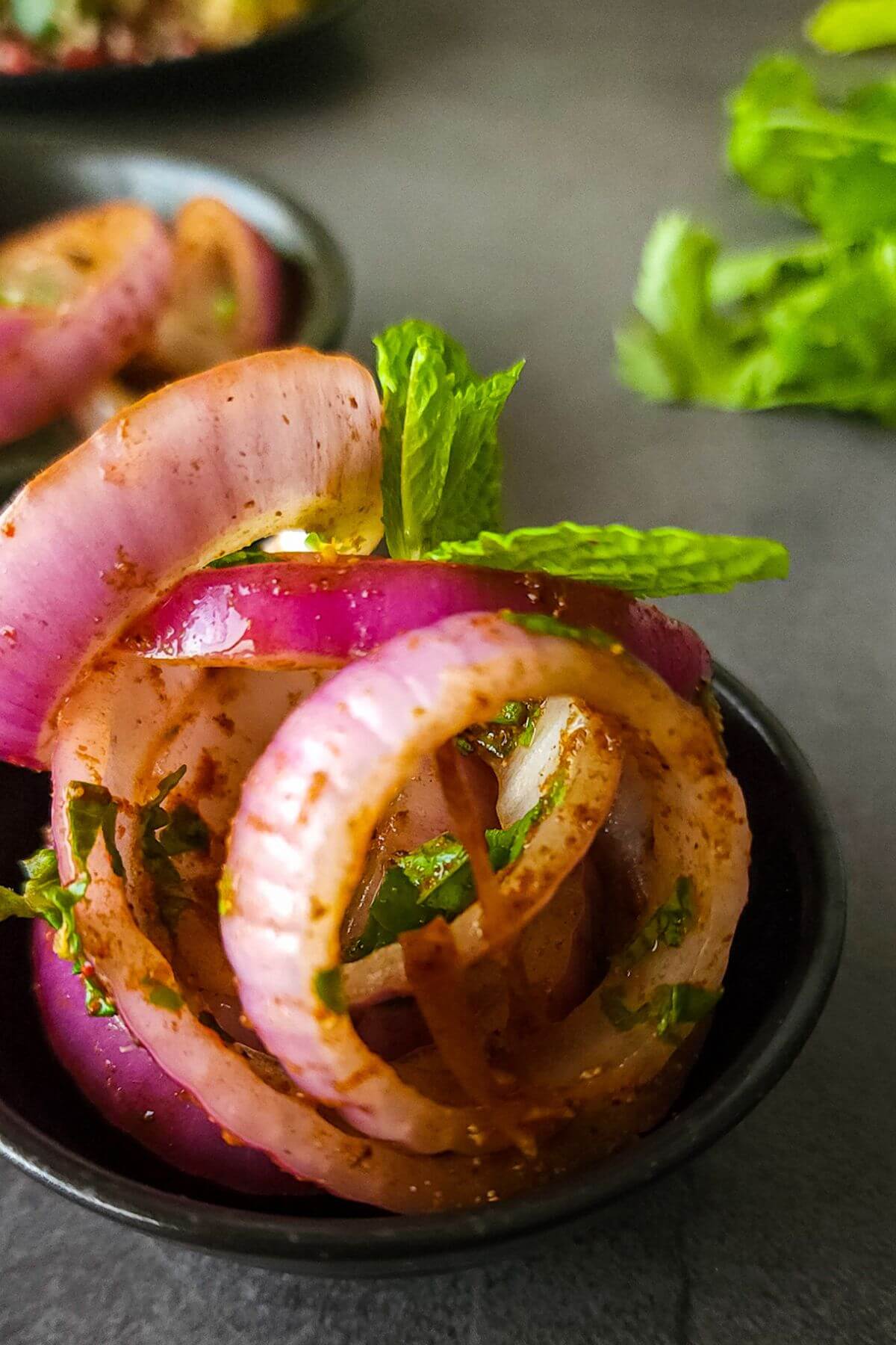 Indian onion salad garnished with mint leaves.