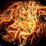Creamy vegan tomato pasta garnished with fresh parsley.