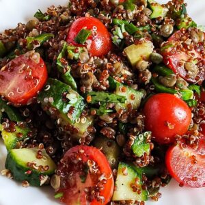 Close up shot of lentil quinoa salad with cherry tomatoes and cucumbers.