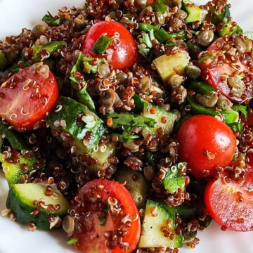 Close up shot of lentil quinoa salad with cherry tomatoes and cucumbers.