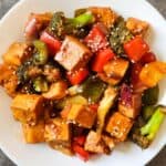 Sweet and sour tofu served on a white plate.