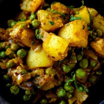 Dry aloo matar garnished with chopped cilantro.