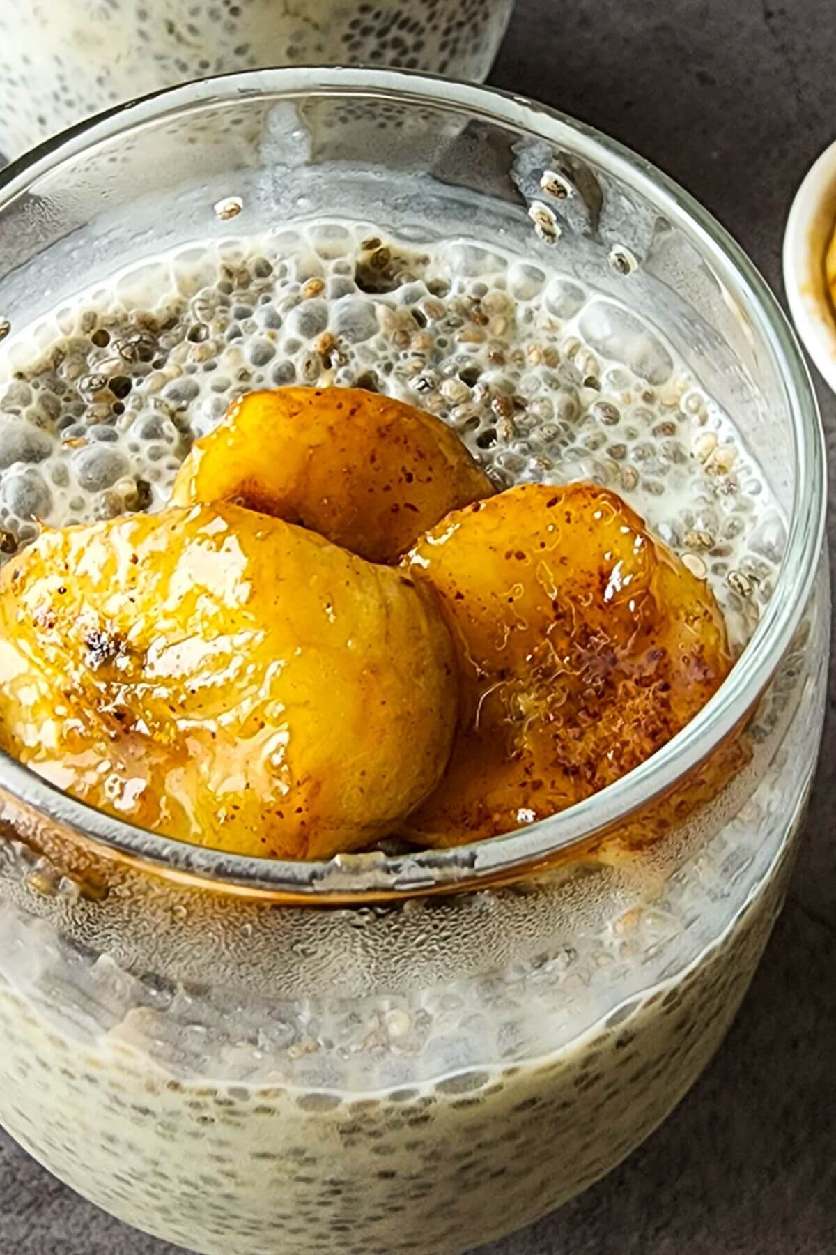 Chia pudding and caramelized banana slices in a glass.