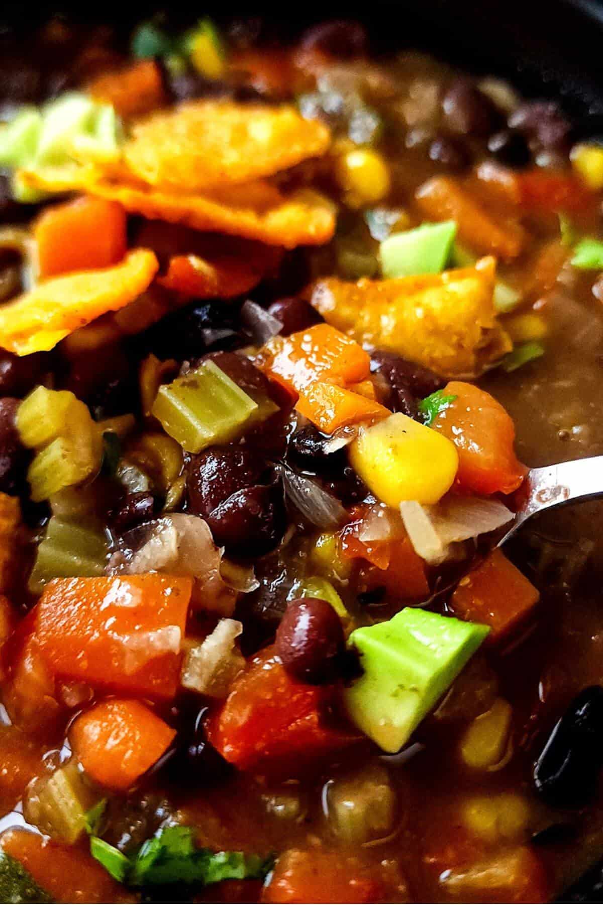Close up shot of vegan black bean soup with corn and vegetables.