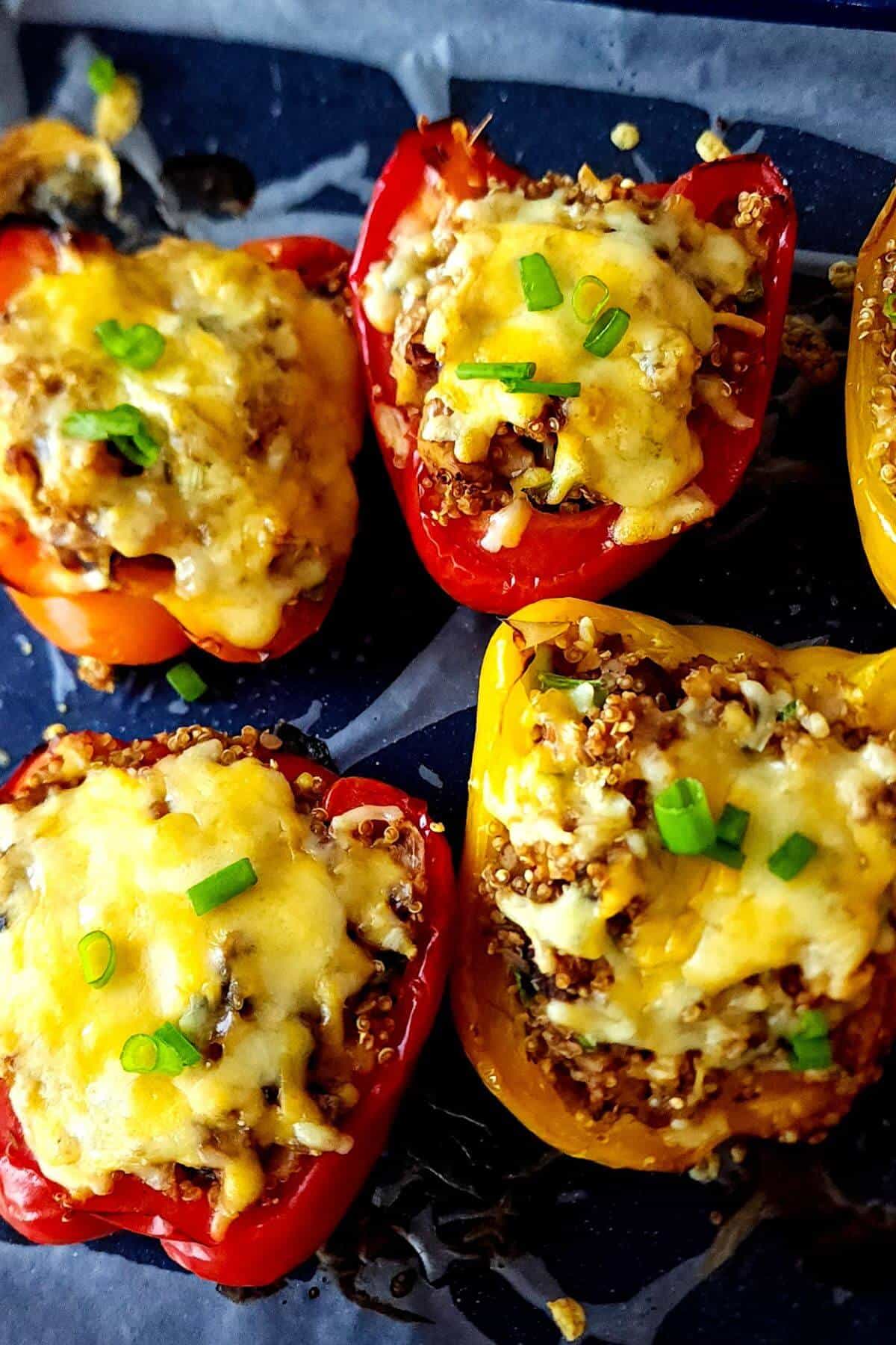 Cheesy mushroom quinoa stuffed bell peppers garnished with chopped spring onion.