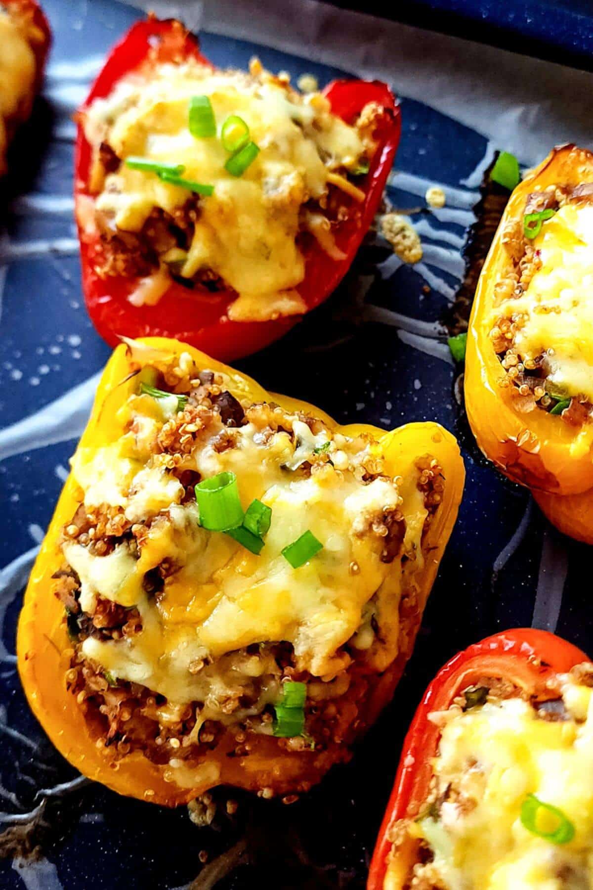 Baked quinoa mushroom bell peppers garnished with chopped spring onion.