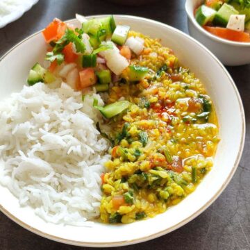 Palak dal served in a bowl with rice and salad