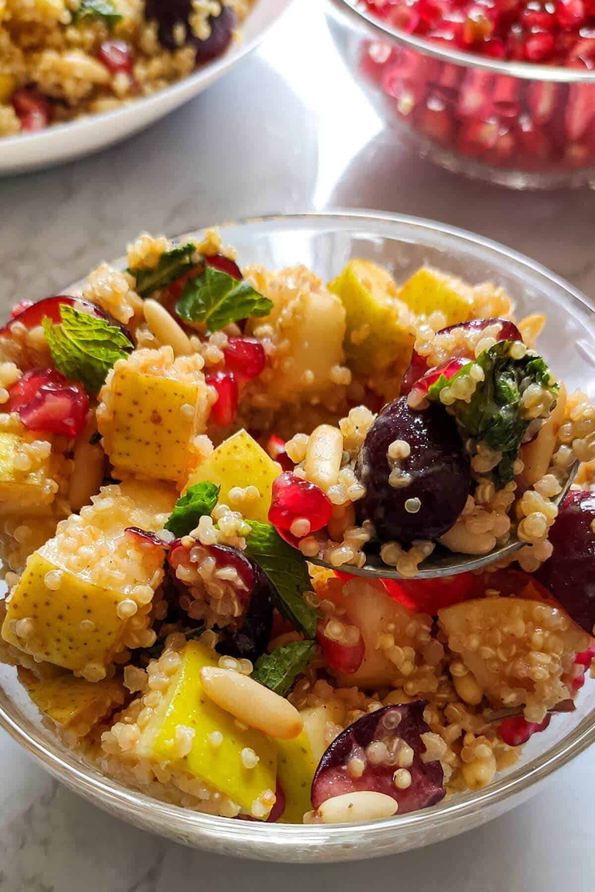 Quinoa fruit salad served in a glass bowl.