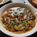 Vegan cabbage soup served in a bowl with a spoon.