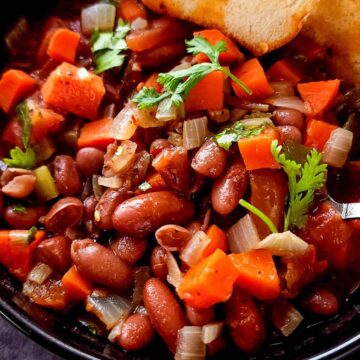 Kidney bean stew with vegetables and cilantro in a bowl.